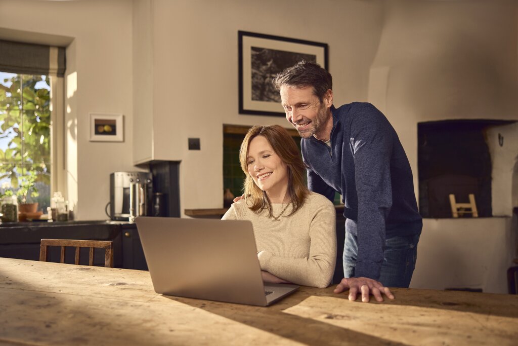Couple video calling on laptop in the kitchen.